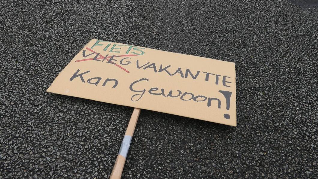 Demonstratiebord op landingsbaan: Fietsvakantie. Kan gewoon.